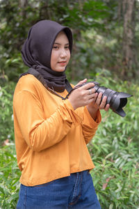 Portrait of young man photographing with camera