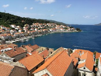 High angle view of townscape by sea against sky