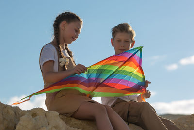 Teenage friends met in nature, talking collecting a kite.