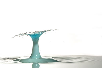 Close-up of water drops on glass against white background