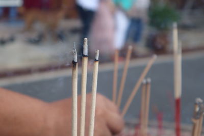 Close-up of hand holding incense sticks