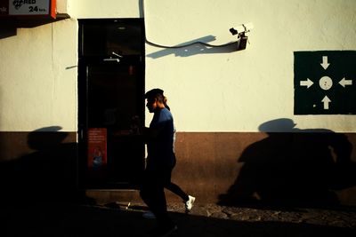 Rear view of men standing against wall