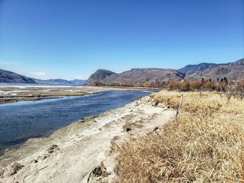 Scenic view of mountains against clear blue sky