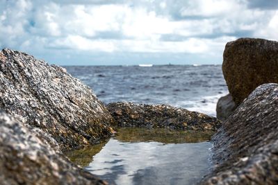 Close-up of rocks in sea against sky