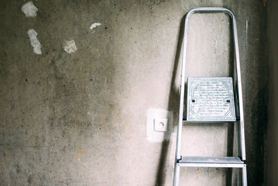 Construction ladder near a gray concrete wall