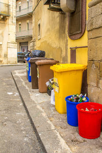 Garbage can on street against building