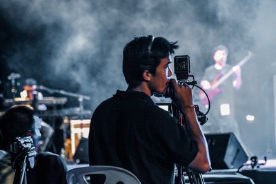 Man using smart phone at music concert