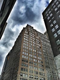 Low angle view of modern building against cloudy sky