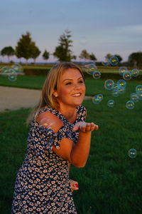 Young woman smiling while standing at bubbles