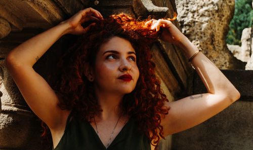 Portrait of young woman with arms raised