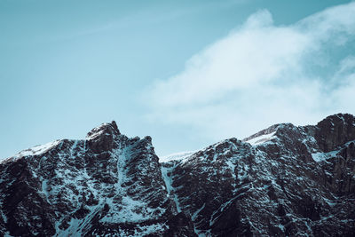 Low-angle view of snowcapped mountains against the sky