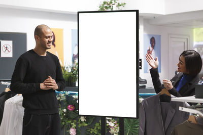 Portrait of man using digital tablet while standing in office