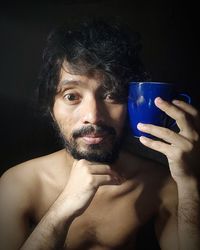 Portrait of shirtless man drinking glass