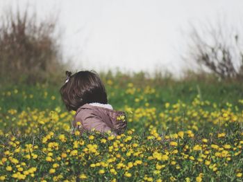 Rear view of girl on field against clear sky