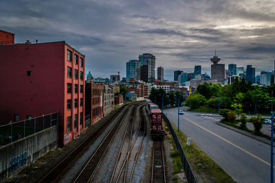 Railroad tracks against cloudy sky