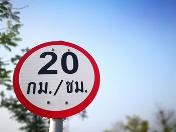 Low angle view of road sign against clear sky