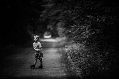 Full length of boy walking on road