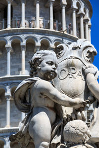 Close-up of statue against historic building