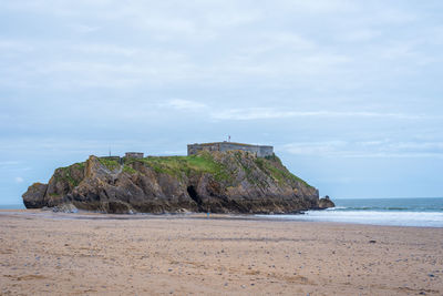 Rocks on beach against sky