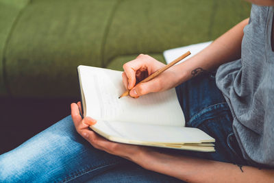 Midsection of woman reading book