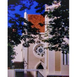 Low angle view of trees and building against sky