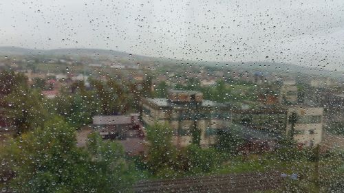 View of cityscape through wet window