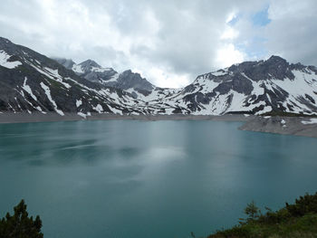 Scenic view of lake and snowcapped mountains against sky