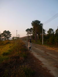 Man walking on road against sky