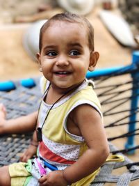 Portrait of smiling boy sitting outdoors