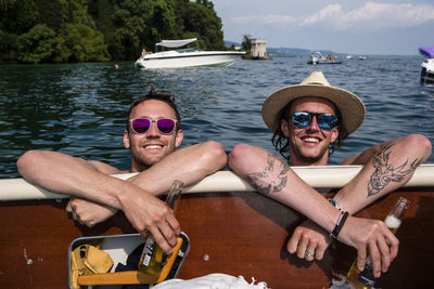 Portrait of young couple sitting on boat sailing in sea