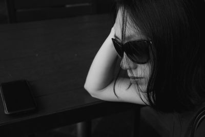 Close-up of woman wearing sunglasses sitting at table in cafe