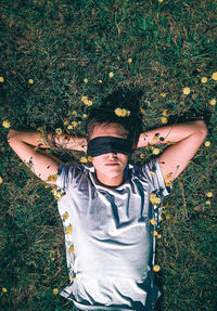 High angle view portrait of boy lying on field