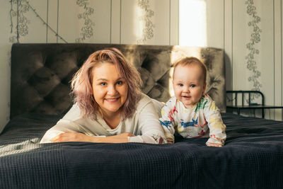 Portrait of mother and son relaxing on bed at home