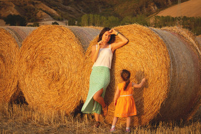 Rear view of woman and her kid standing on hay