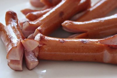 Fried sausages on white table