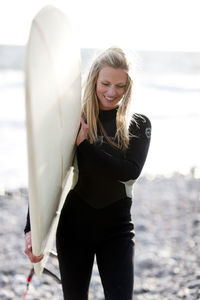 Woman with surfboard on beach