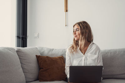 Young woman using digital tablet while sitting at home