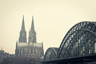 Cologne cathedral and hohenzollern bridge against clear sky in city