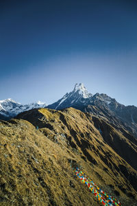 Scenic view of snowcapped mountains against clear blue sky