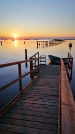 Pier over sea against sky during sunset