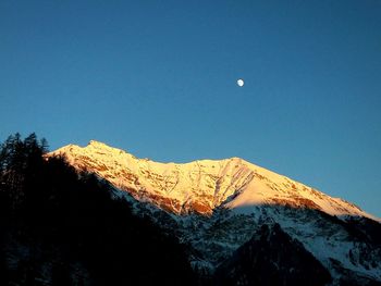 Low angle view of landscape against clear blue sky