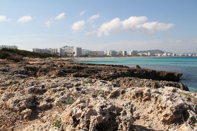 Scenic view of sea by buildings against sky