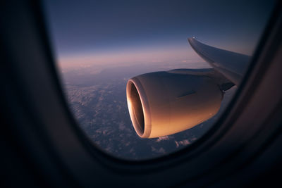 Cropped image of airplane wing against sky during sunset