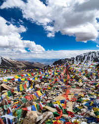 Multi colored flags on mountain against sky