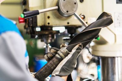 Man wearing gloves working with equipment at factory