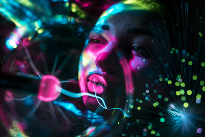 Digital composite image of woman and plasma ball with fiber optics