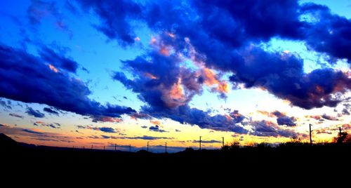 Silhouette of landscape against cloudy sky