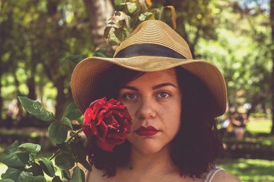 Close-up portrait of beautiful woman with red flowers