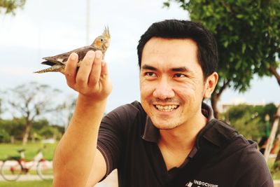 Man holding bird against sky