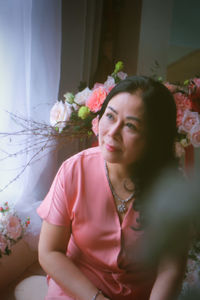 Portrait of young woman sitting on sofa at home